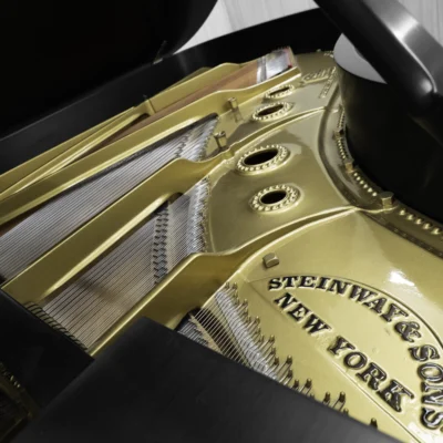 A 1911 Steinway A piano in a beautiful hand-rubbed satin ebony finish with nickel hardware. This image shows off the interior of the piano, including the harp and strings.