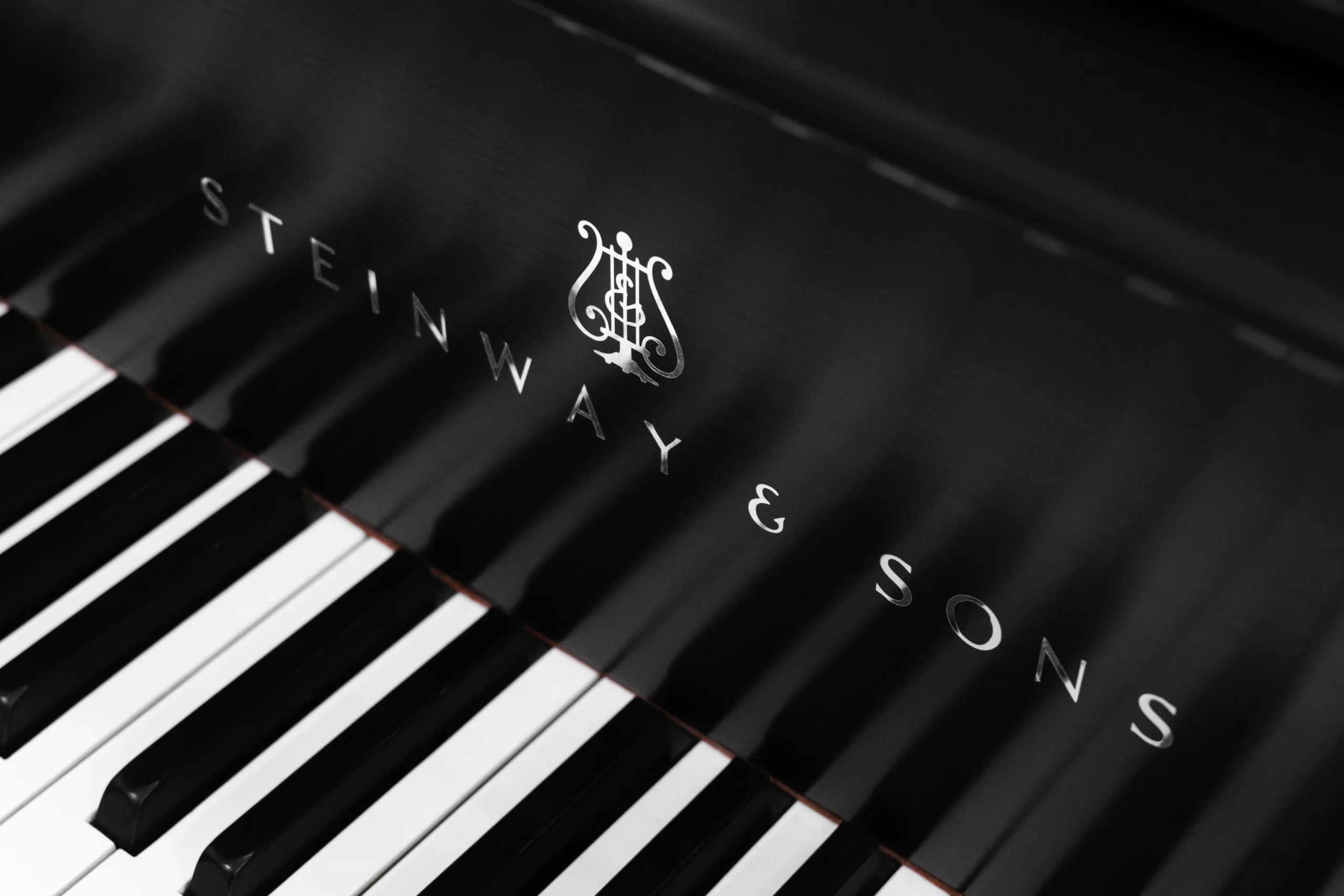 A 1911 Steinway A piano in a beautiful hand-rubbed satin ebony finish with nickel hardware. This image shows off the interior of the piano, including the harp and strings. This image shows off the keys and Steinway Logo on the fallboard.