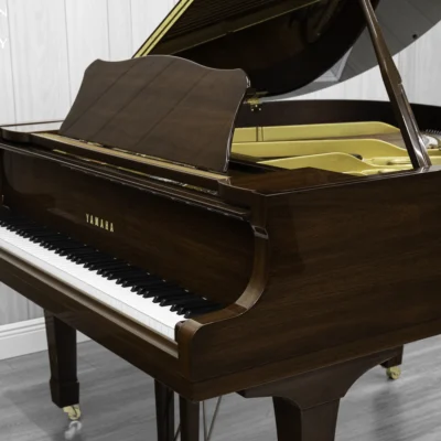 A Yamaha G1 piano in a beautiful mahogany finish with brass hardware.