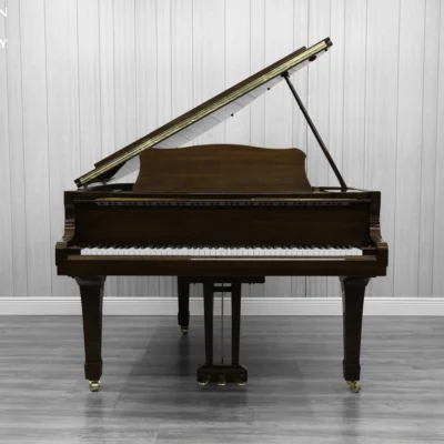 A Yamaha G1 piano in a beautiful mahogany finish with brass hardware.