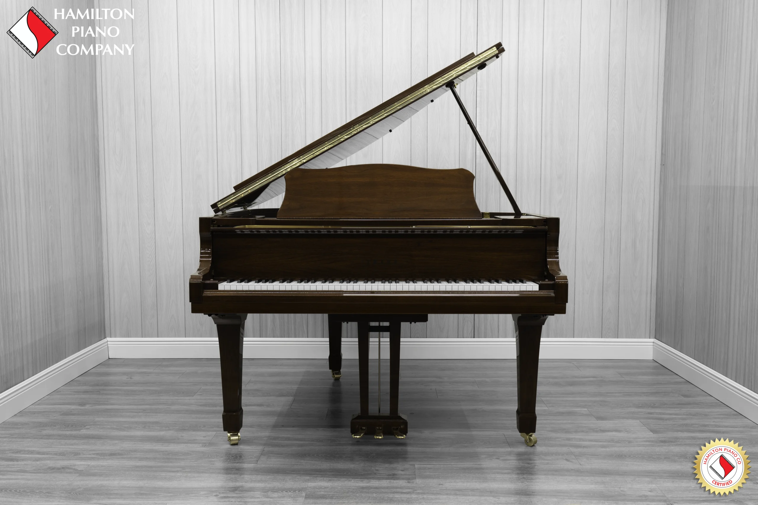 A Yamaha G1 piano in a beautiful mahogany finish with brass hardware.