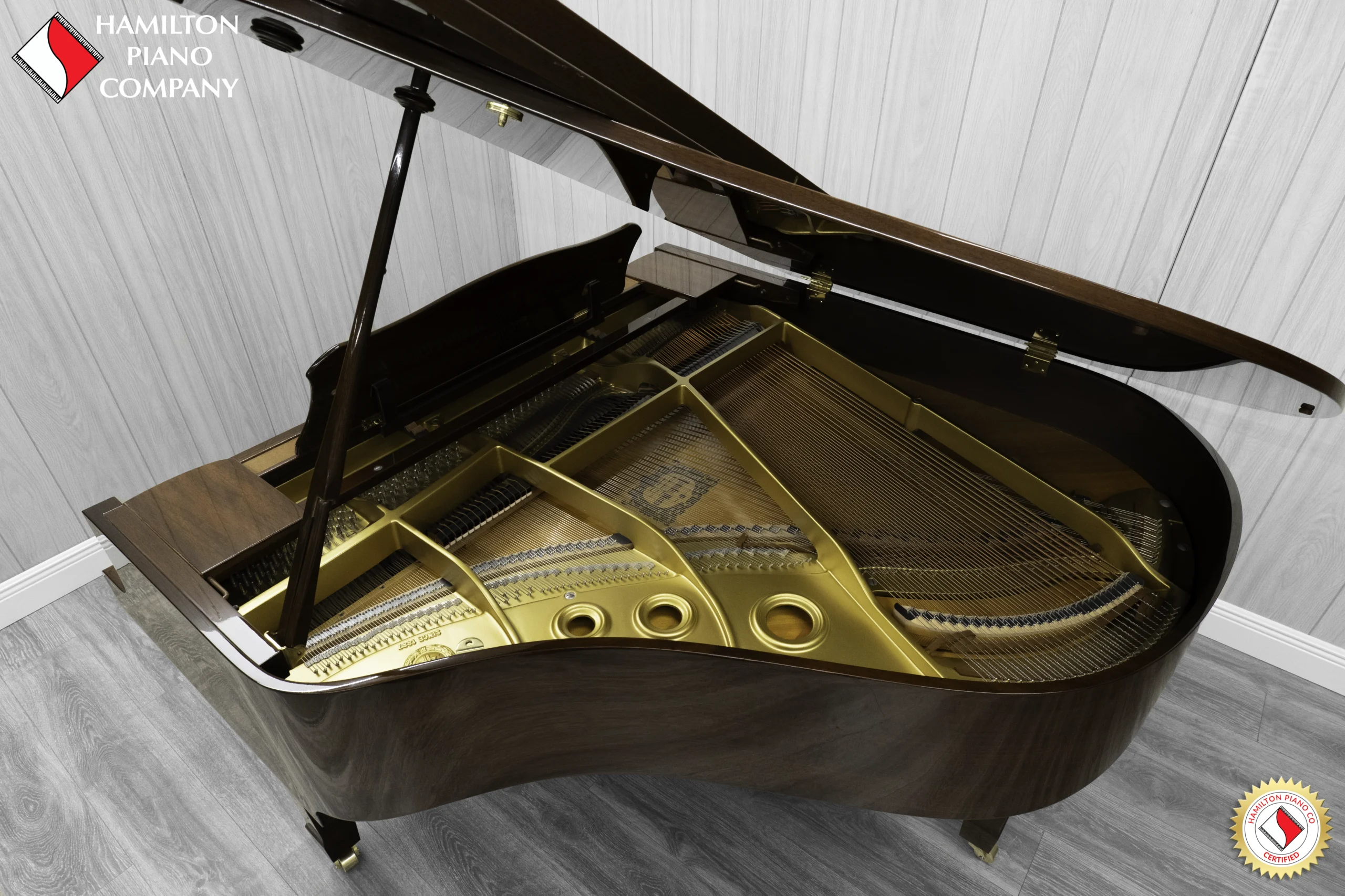 A Yamaha G1 piano in a beautiful mahogany finish with brass hardware. This image shows off the interior of the piano including the harp and strings.