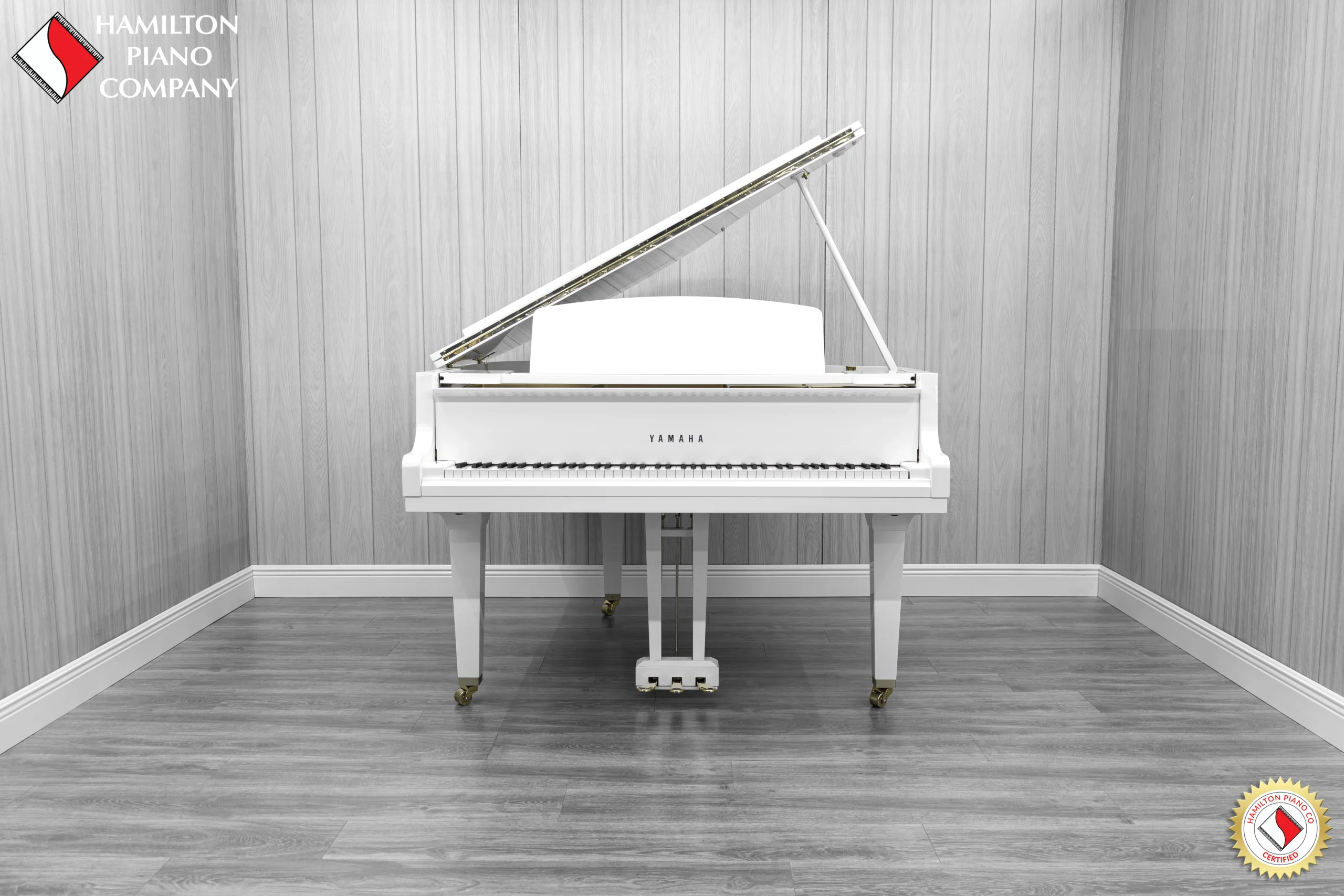 A Yamaha GH1 baby grand piano in a high polish white finish