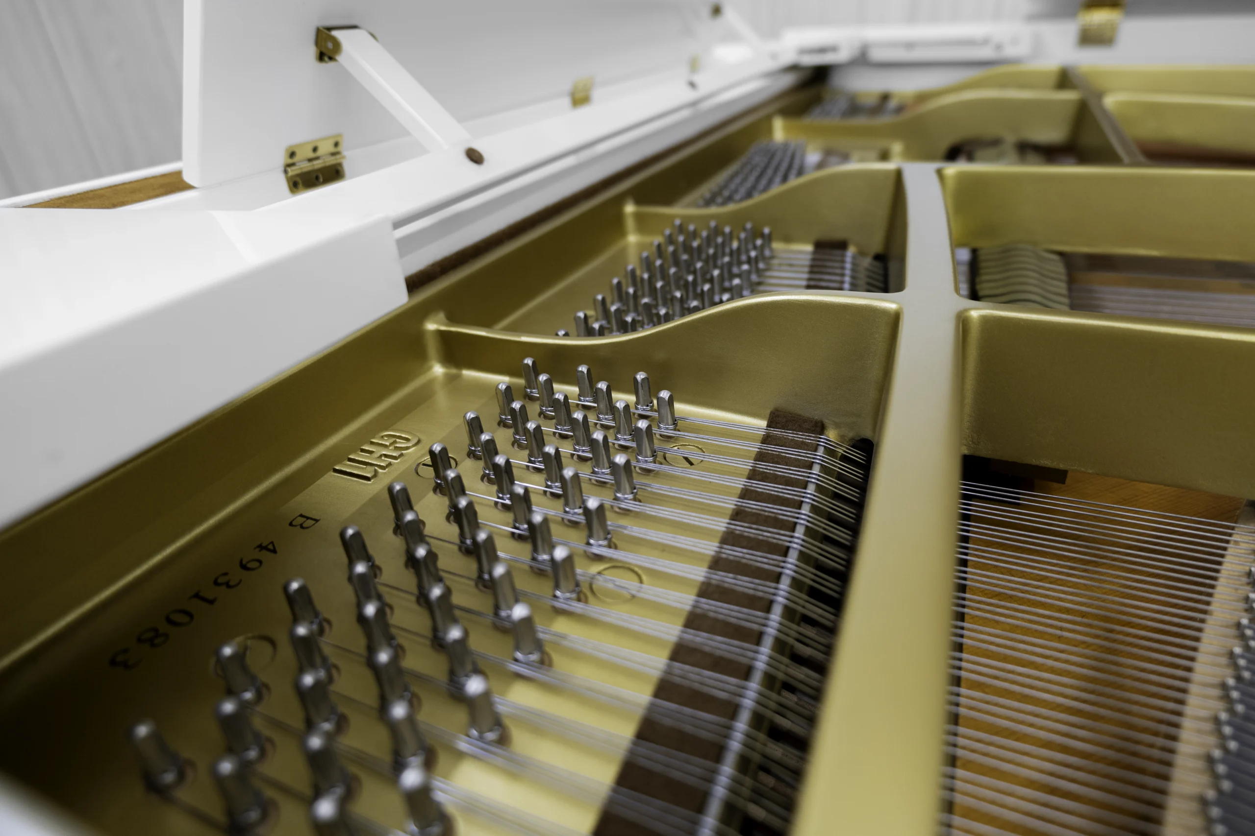 A Yamaha GH1 baby grand piano in a high polish white finish