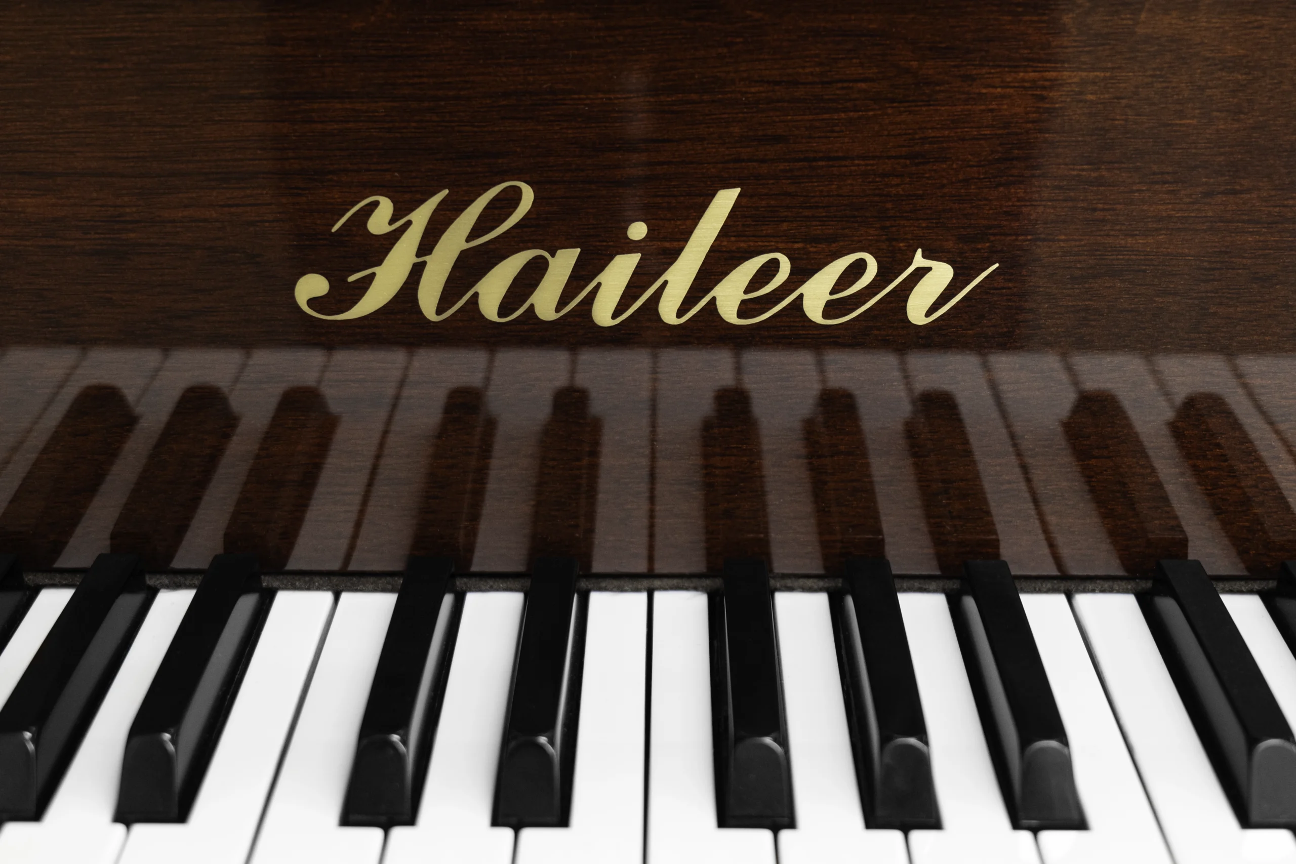 Haileer baby grand piano in high polish mahogany.