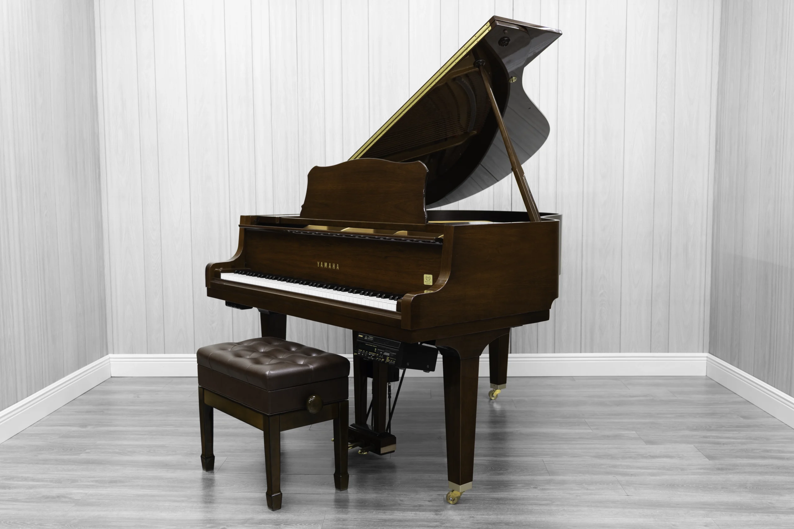 A pre-owned Yamaha GH1 baby grand piano in a beautiful mahogany finish with brass hardware.