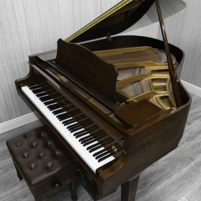 A pre-owned Yamaha GH1 baby grand piano in a beautiful mahogany finish with brass hardware.