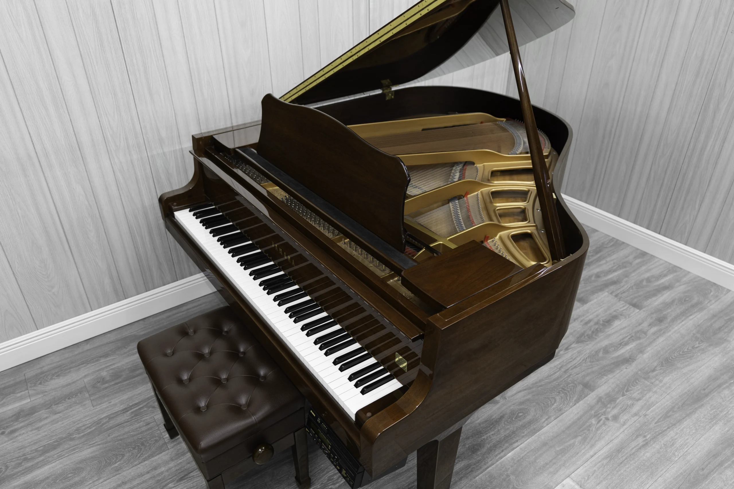 A pre-owned Yamaha GH1 baby grand piano in a beautiful mahogany finish with brass hardware.